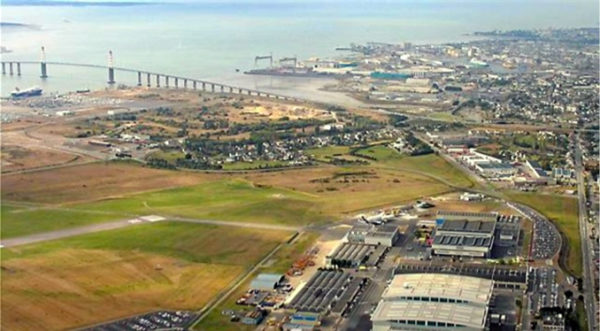 Sur cette photo datant de quelques années, on peut observer de gauche à droite et de bas en haut, la piste de l’aéroport, les usines Airbus, le nouveau port de Saint-Nazaire, le Pont de Saint-Nazaire, les chantiers navals STX, et la ville de Saint-Nazaire (5)
