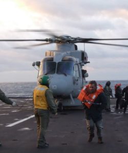 Des passagers sauvés sont débarqués d'un hélicoptère militaires italiens.