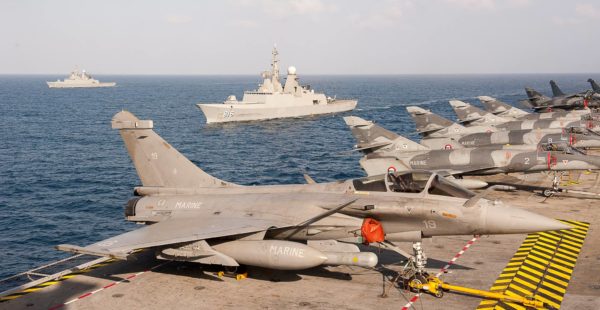 Les avions de combat français parqués sur le pont d'envol du CDG. En arrière-plan on aperçoit les deux frégates saoudiennes.