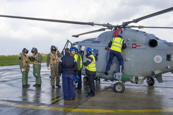 Personnels britanniques et français s'affairent autours d'un Lynx de la Royal Navy.